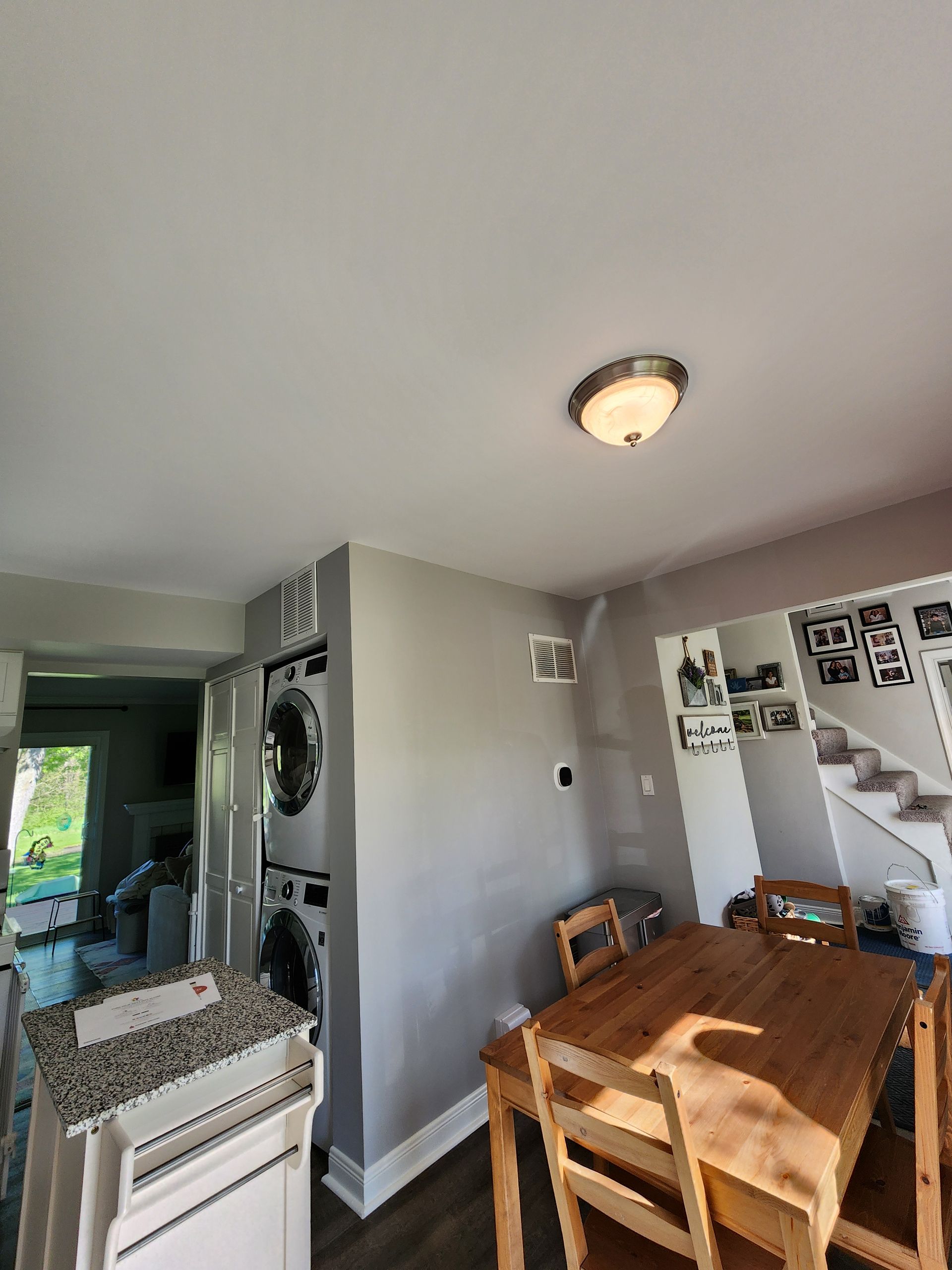 A kitchen with a wooden table and chairs and a washer and dryer.