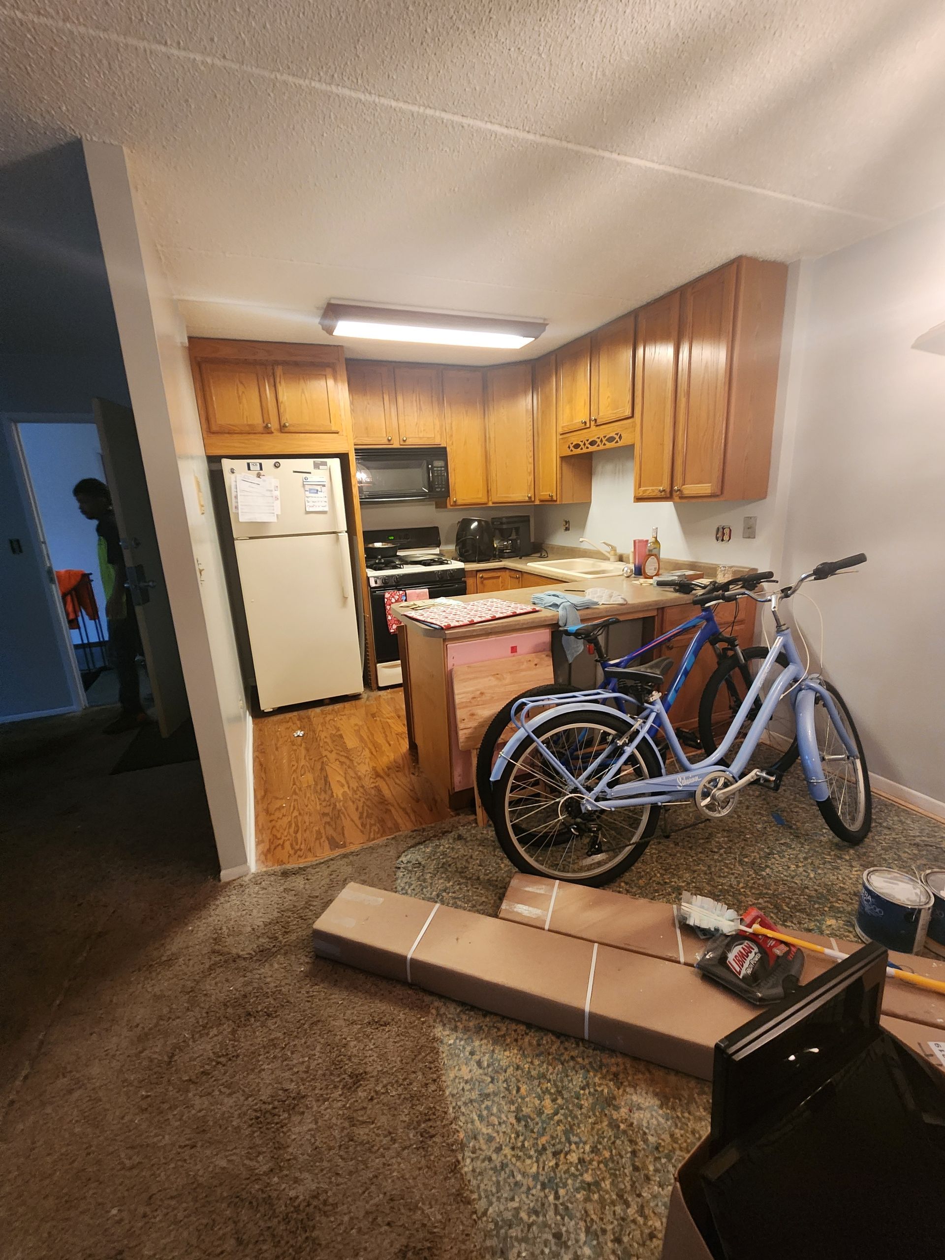 A bicycle is parked in a kitchen next to a refrigerator.