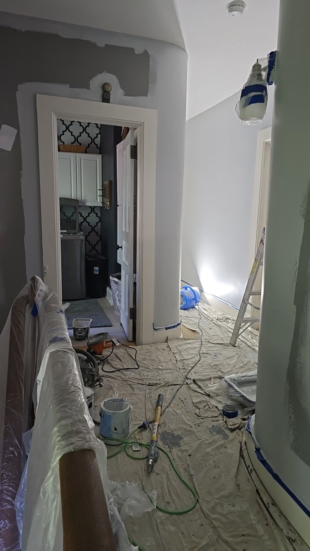 A hallway is being painted in a house.