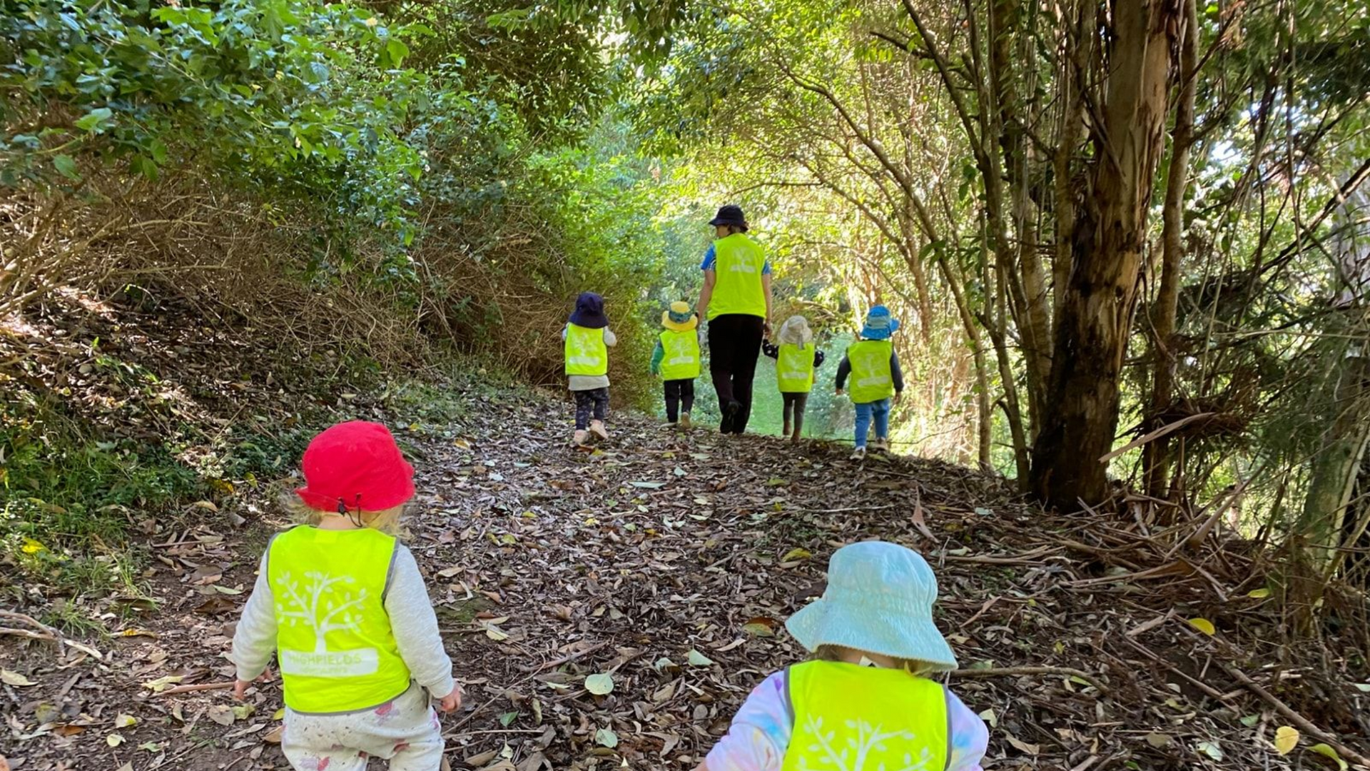 children and educators in high vis vests on a bush kindy excursion