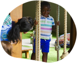 Woman and two children looking up with surprised expressions in a garden setting.