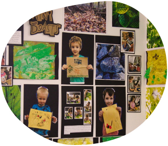 Children's artwork and photos on a wall. Includes art, pictures of the kids, and nature images.