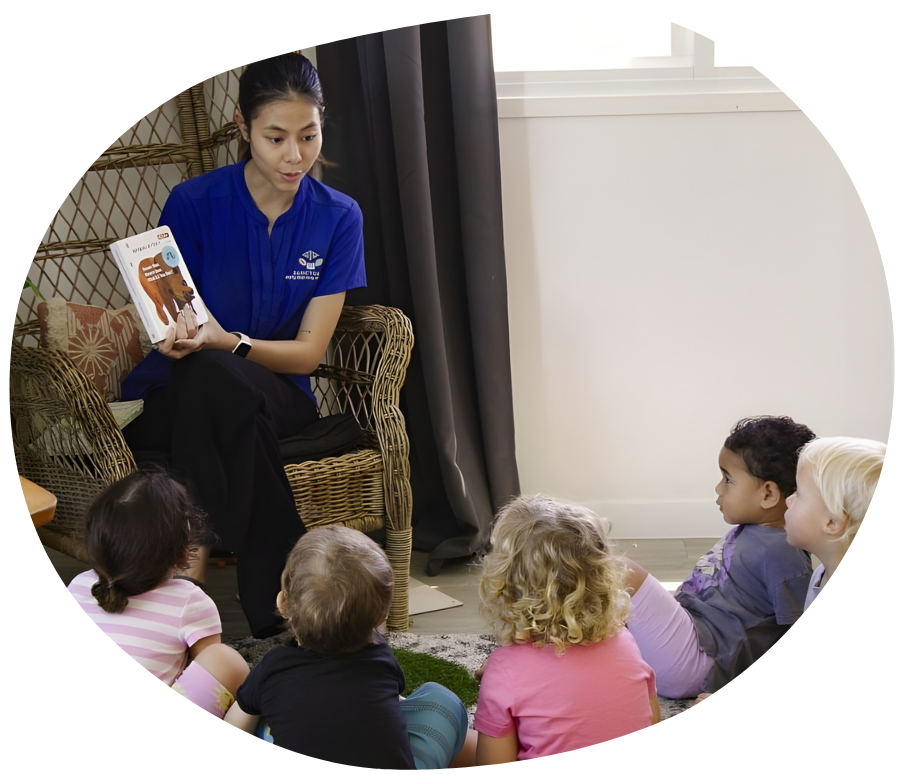 Woman in glasses shows toy to child at table.