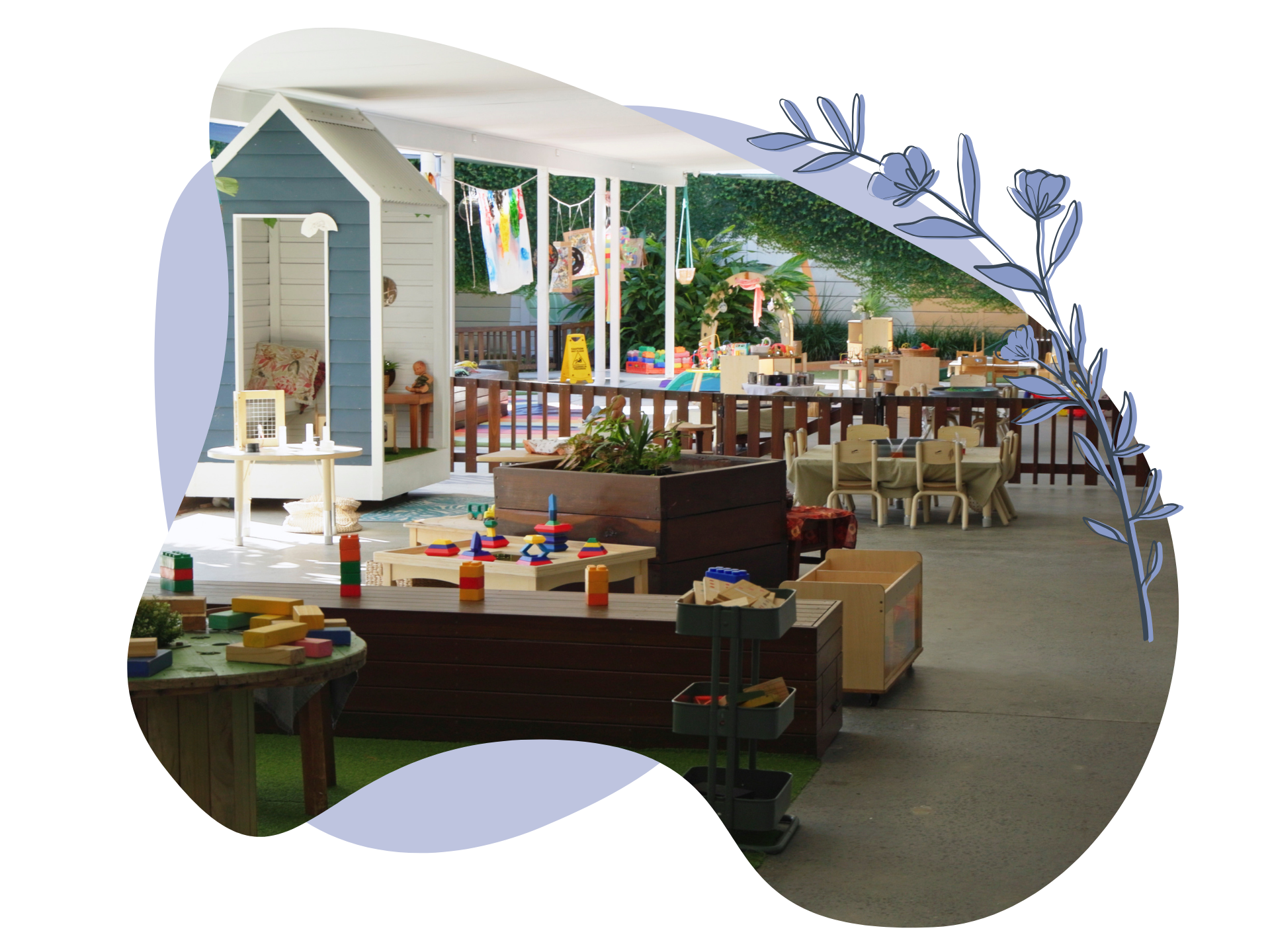 Outdoor play area with small house, tables, and toys.