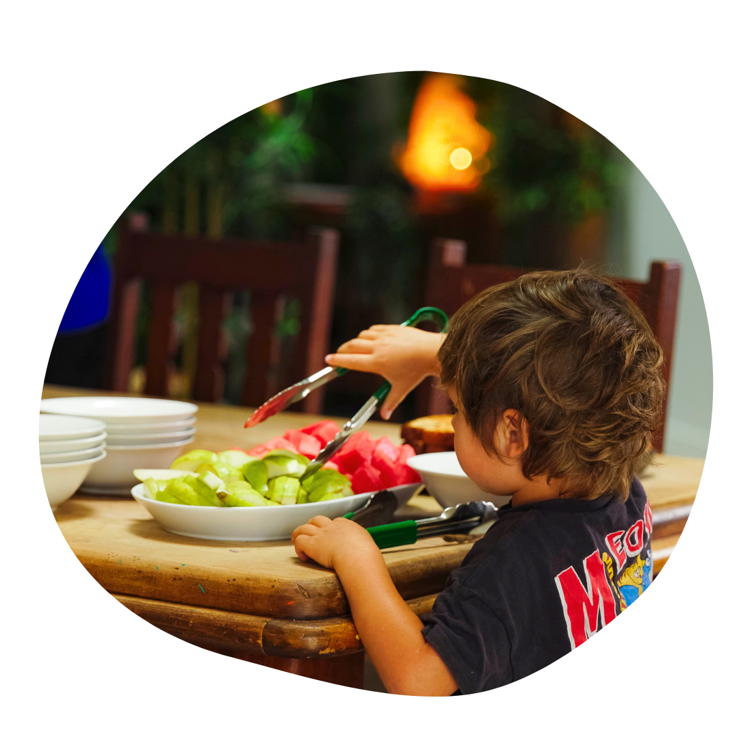 Young child playing with an abacus, smiling.