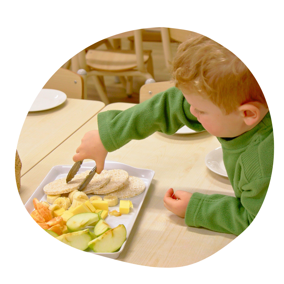 Children with blue paint on hands playing with an adult who is laughing.