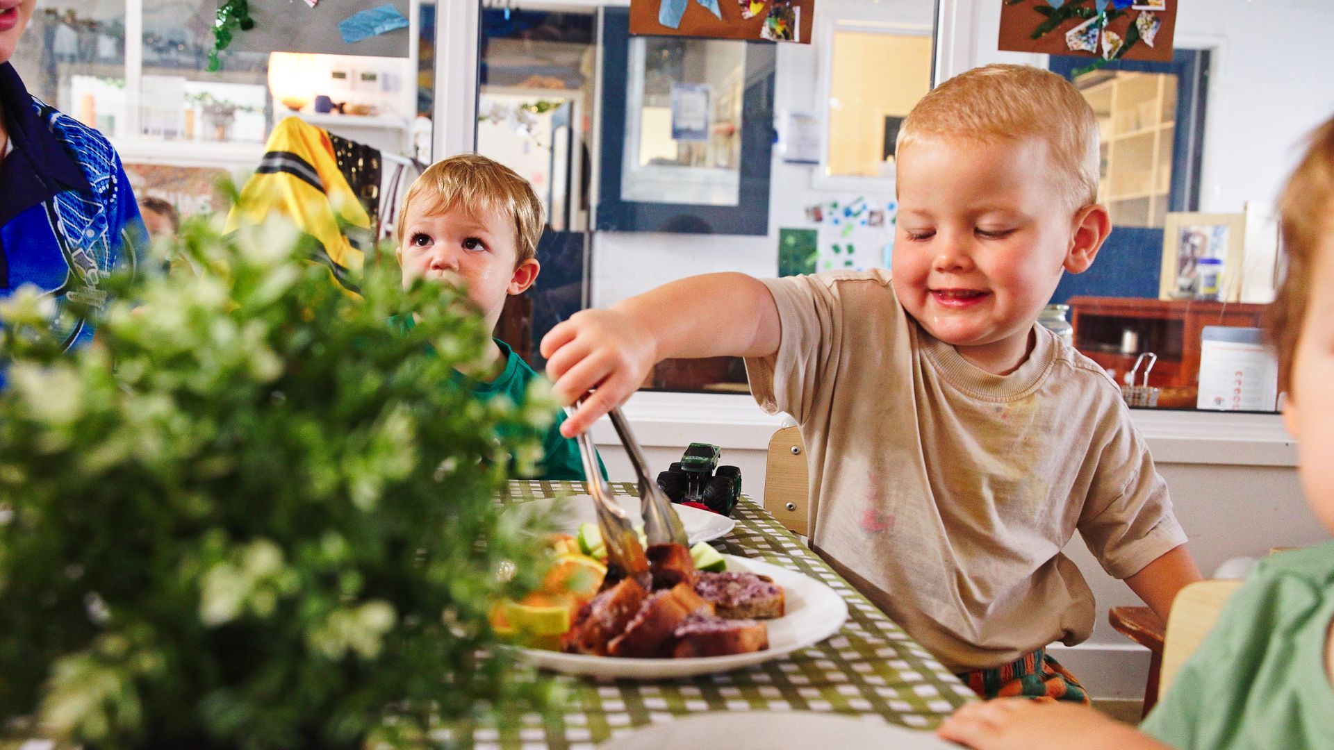 happy child serving themselves food at a table