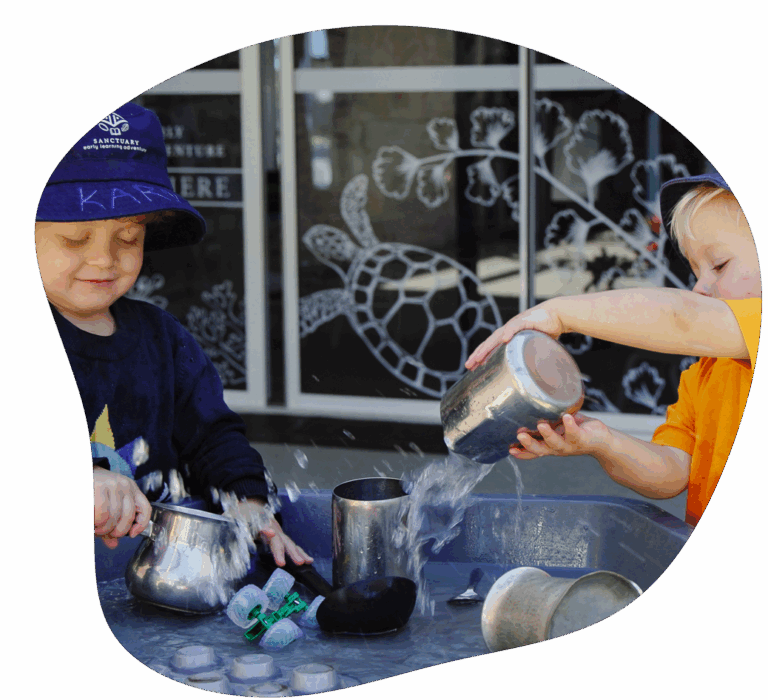 Children playing with water and metal containers outdoors.