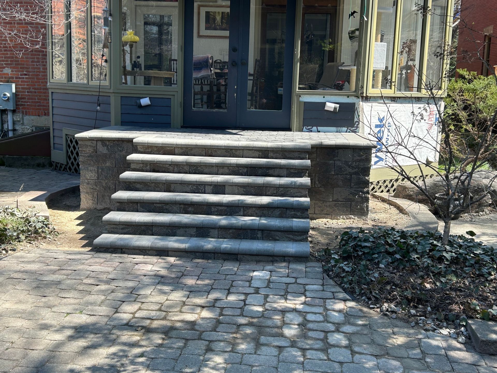 Stone steps and walkway leading to a house with a dark blue door.