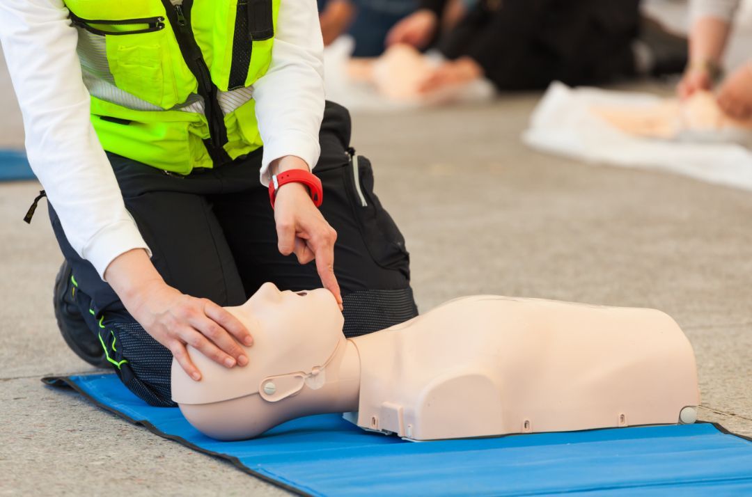 An individual practicing CPR techniques in a classroom setting with CPR-Professionals LLC