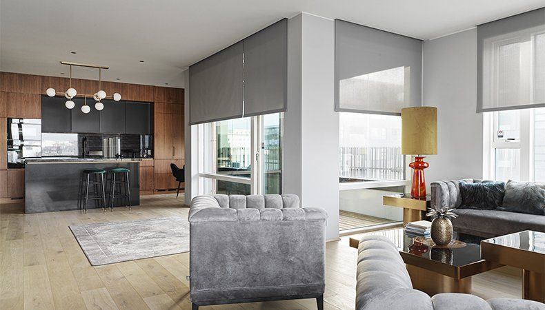 A living room with a couch , chair , table and a kitchen.