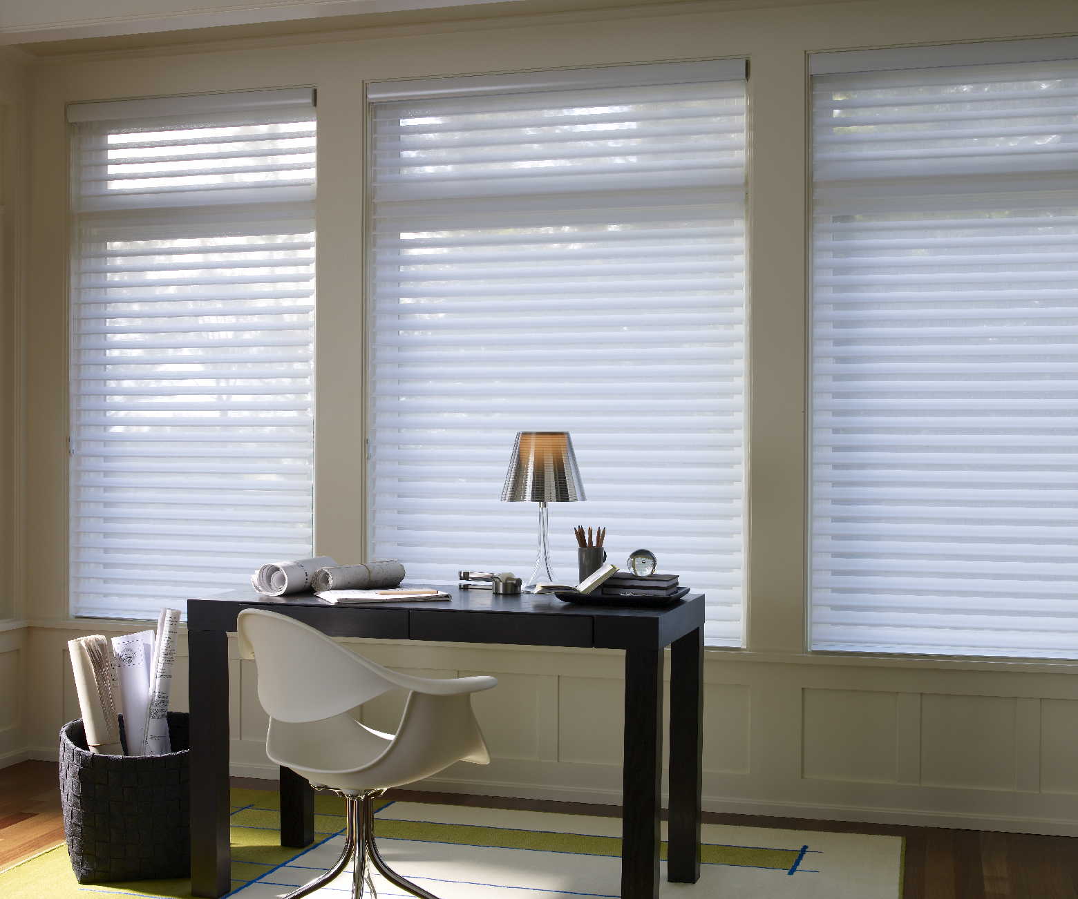 A desk and chair in a room with white blinds