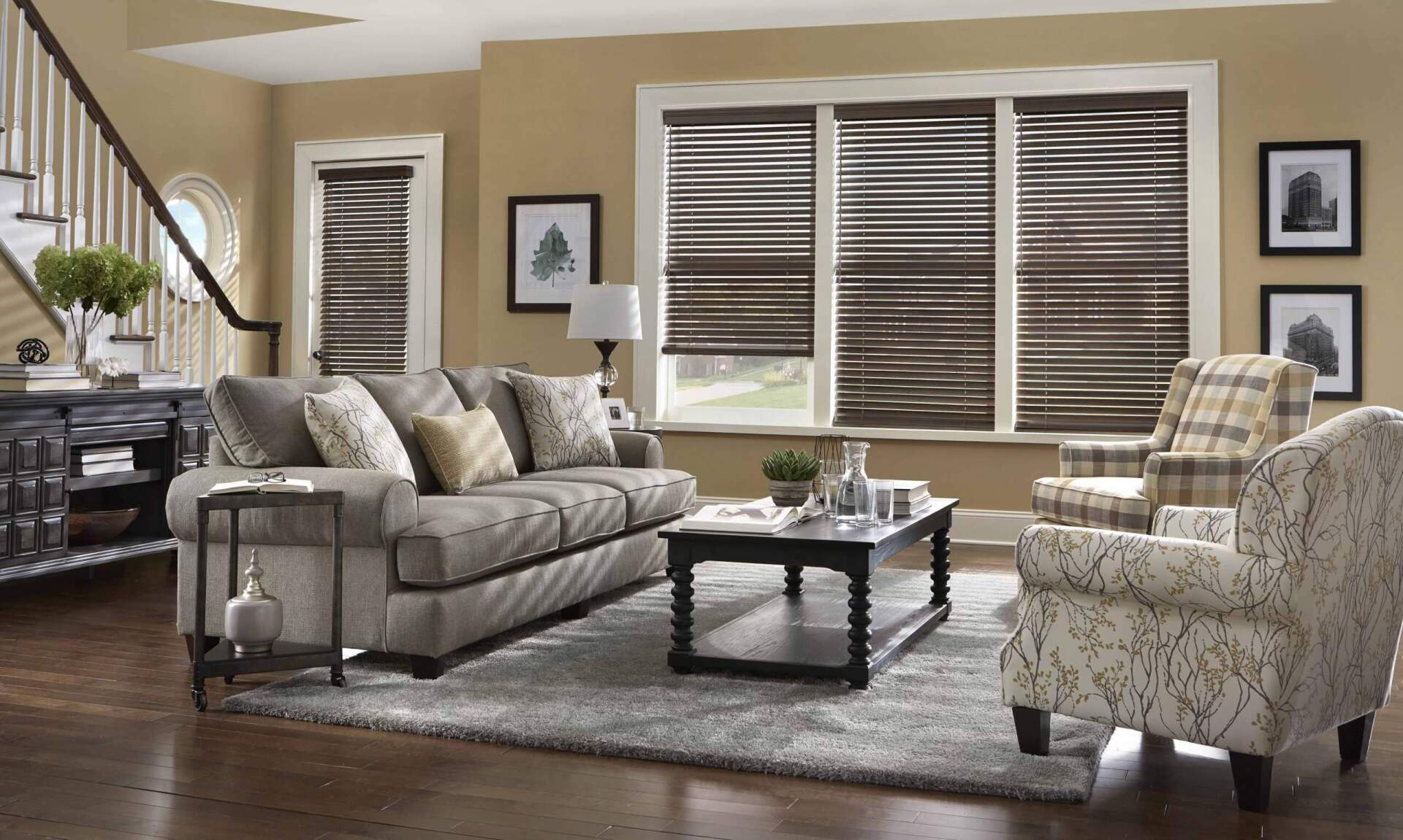 A living room with a couch , chairs , coffee table and blinds.