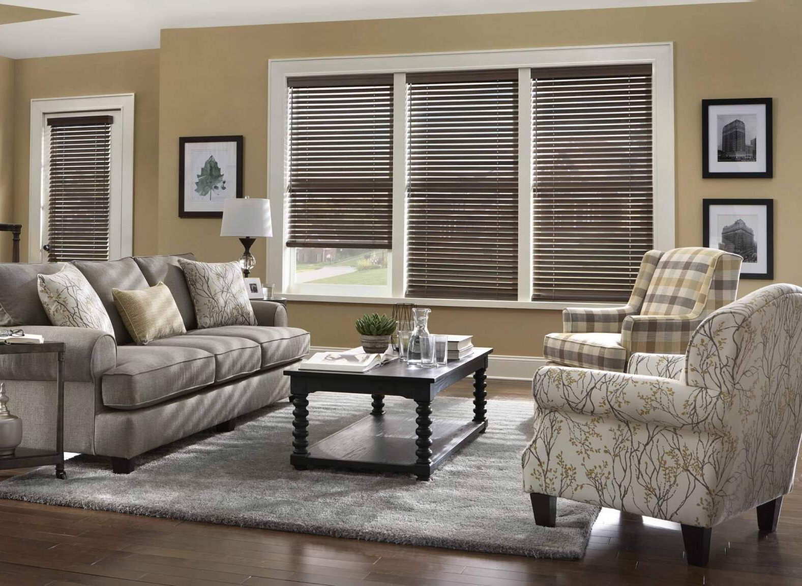 A living room with a couch , chairs , coffee table and blinds