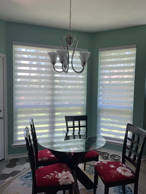 A dining room with a glass table and chairs and a chandelier.