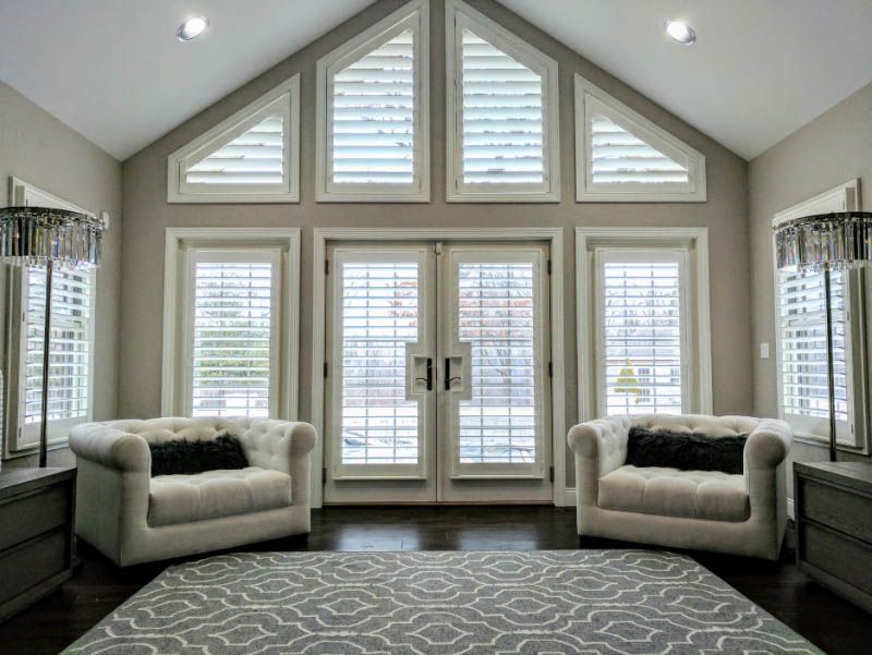 A living room with two chairs , a rug , and a vaulted ceiling.