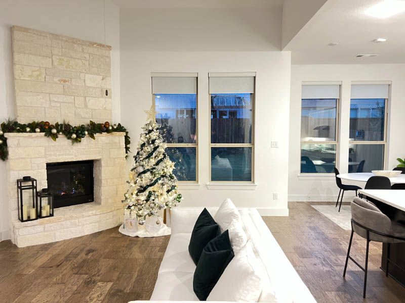 A living room with a couch a fireplace and a christmas tree