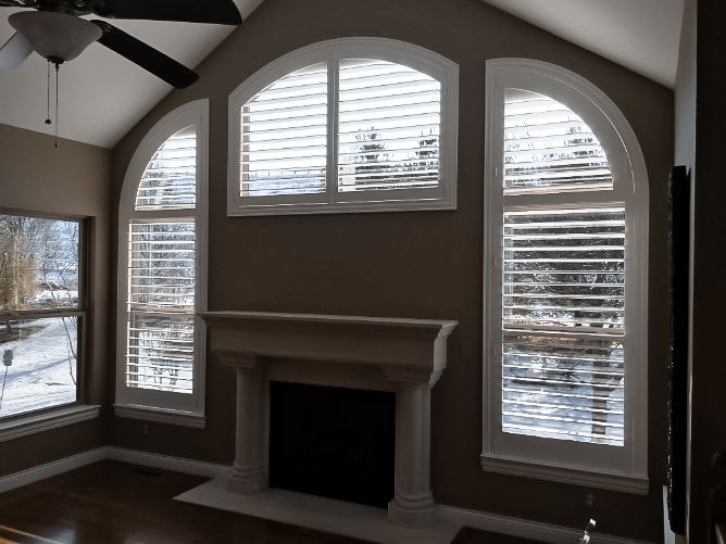 Beautiful living room with curved white plantation shutters on windows Love is Blinds Kentucky