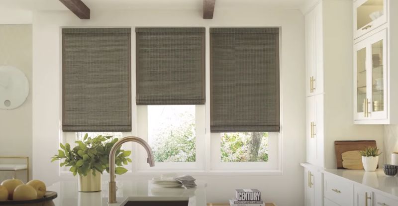 A kitchen with a sink , cabinets , and a window with blinds.