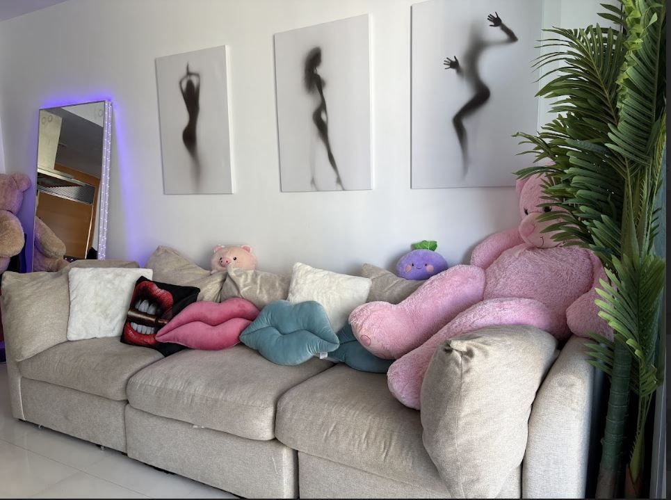 A living room with a couch filled with stuffed animals and pillows.