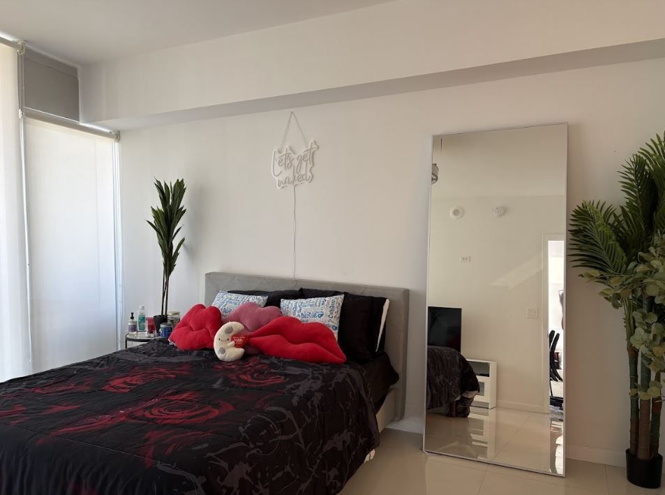 A bedroom with a bed and a large mirror