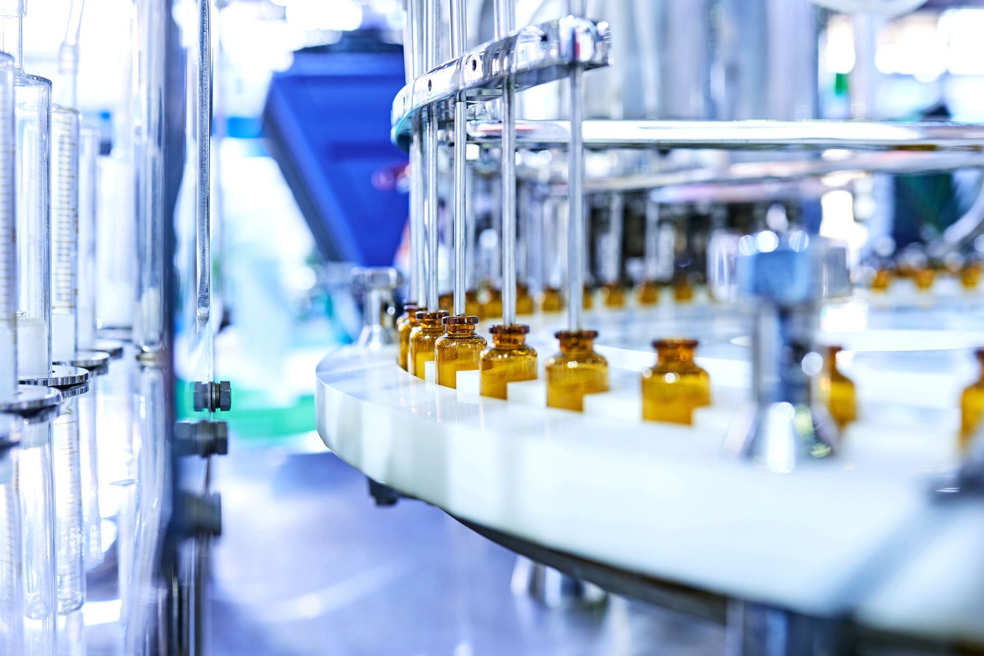 Bottles on a manufacturing line, likely pharmaceutical, inside a clean room.