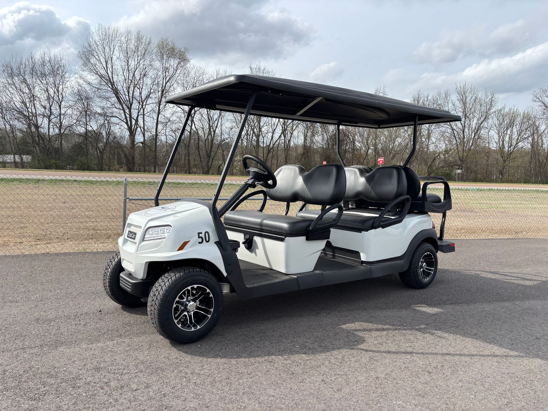 A group of people are riding in a golf cart.