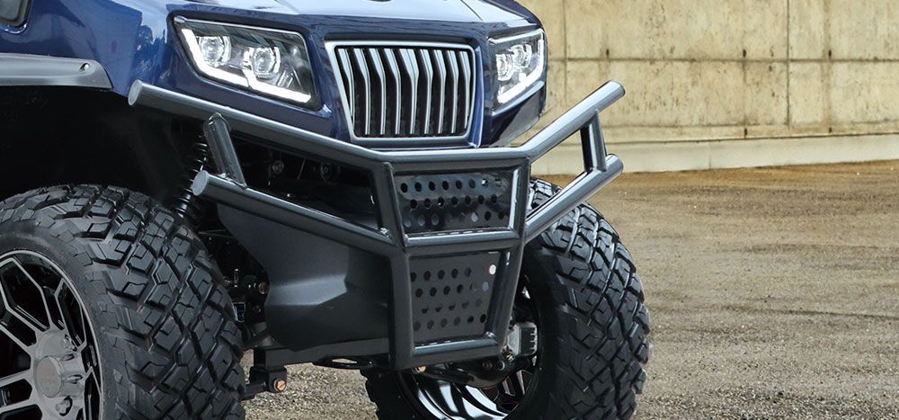 A blue atv with a bumper is parked in a parking lot.