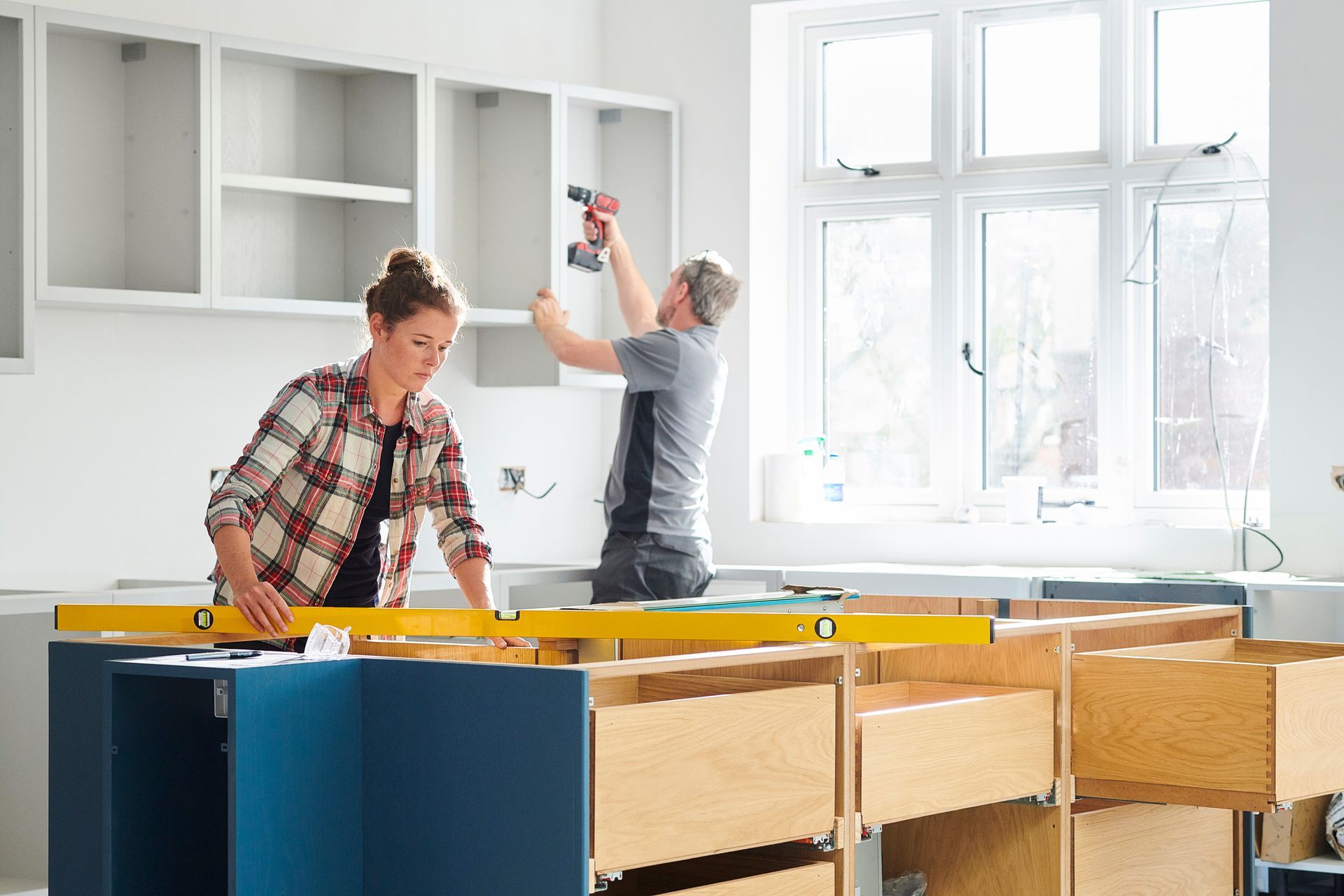 A Man and A Woman Are Working on A Kitchen.