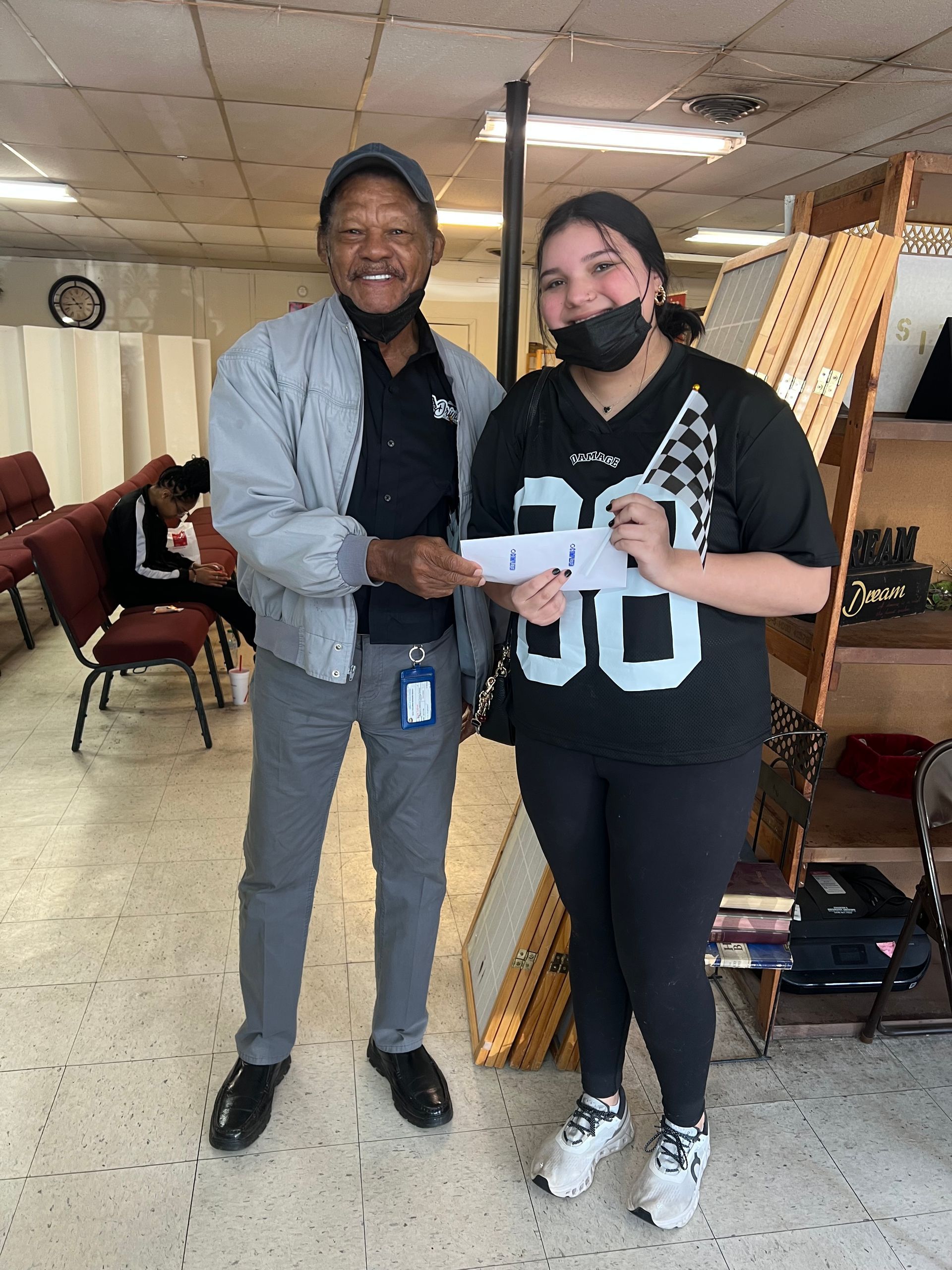 A man is giving a woman a check in a room.