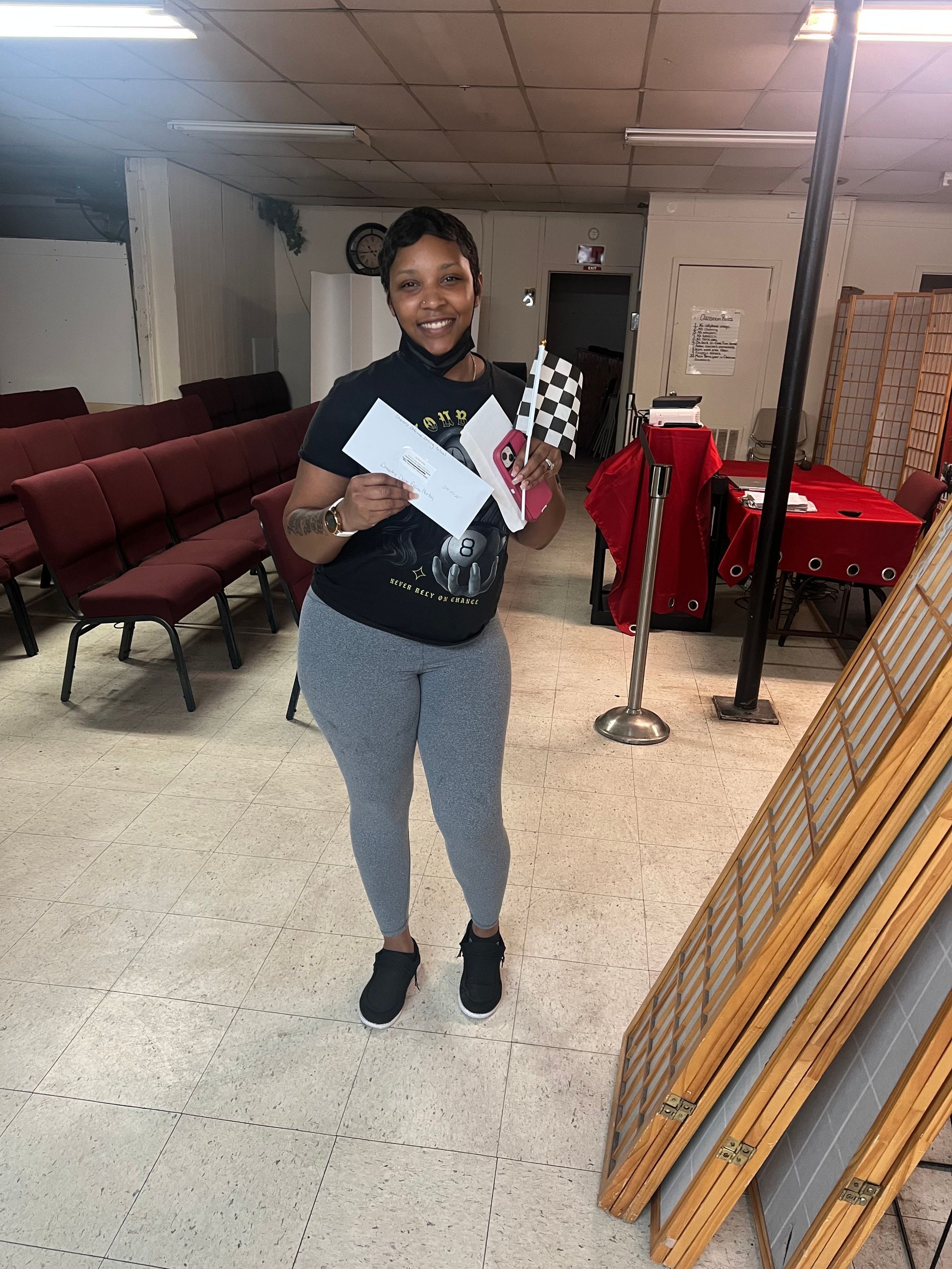 A woman is standing in a room holding a piece of paper.