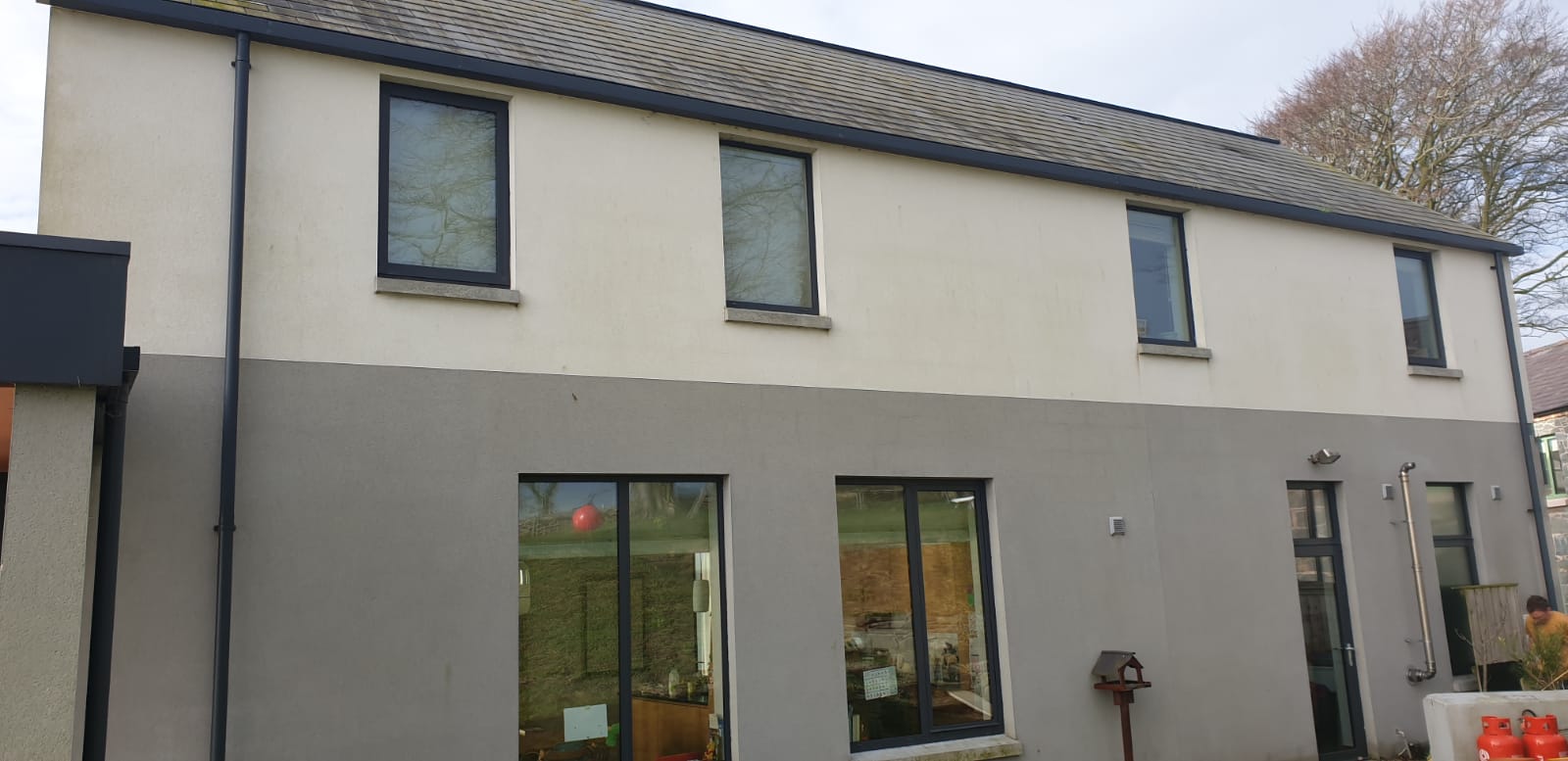 A large white house with a black roof and a lot of windows.