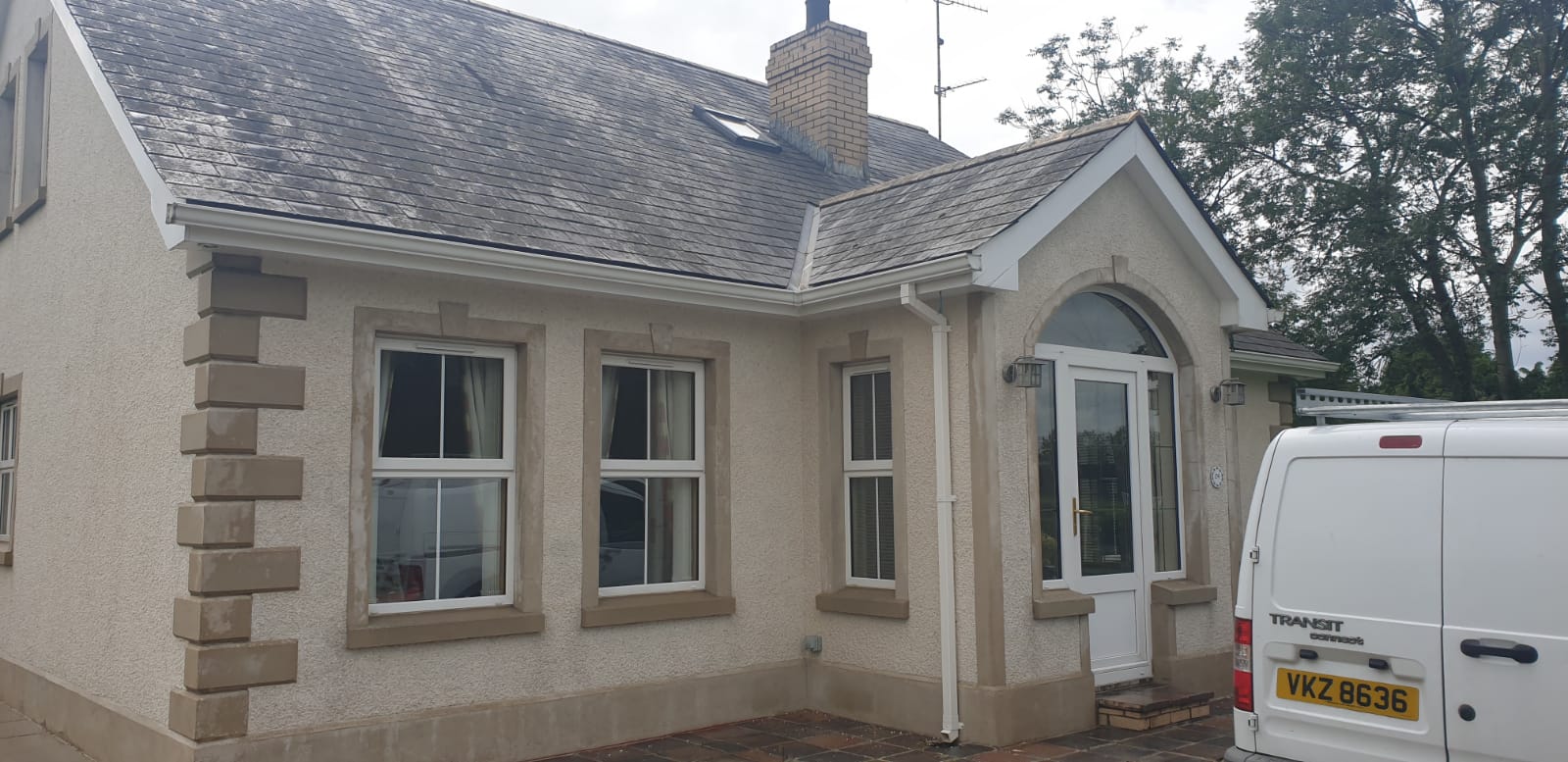 A white van is parked in front of a house.