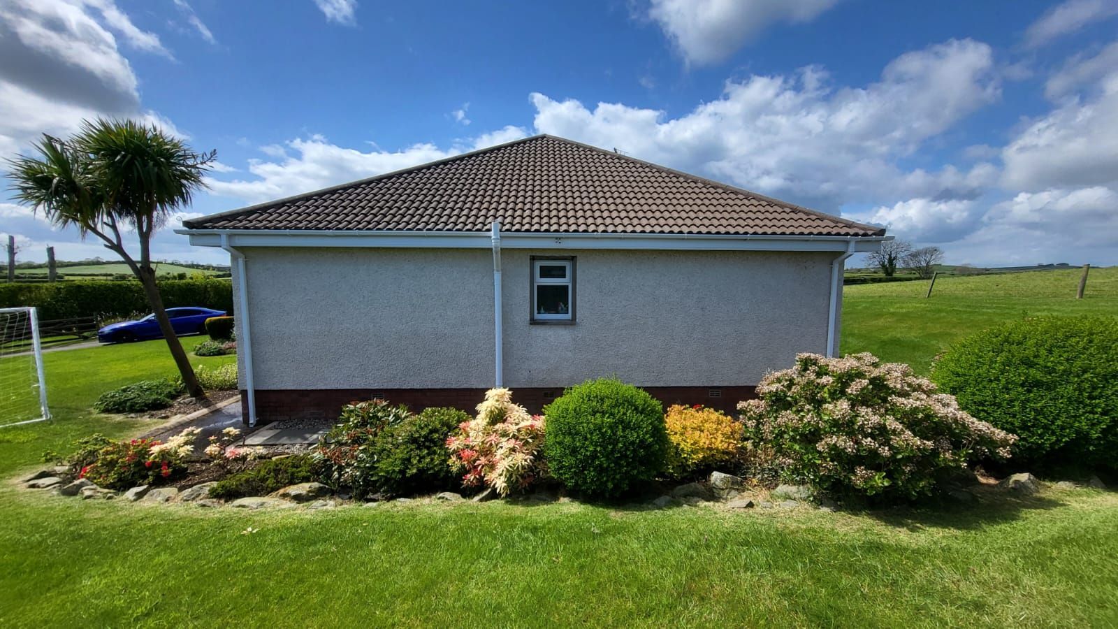 A small house with a brown roof and a window