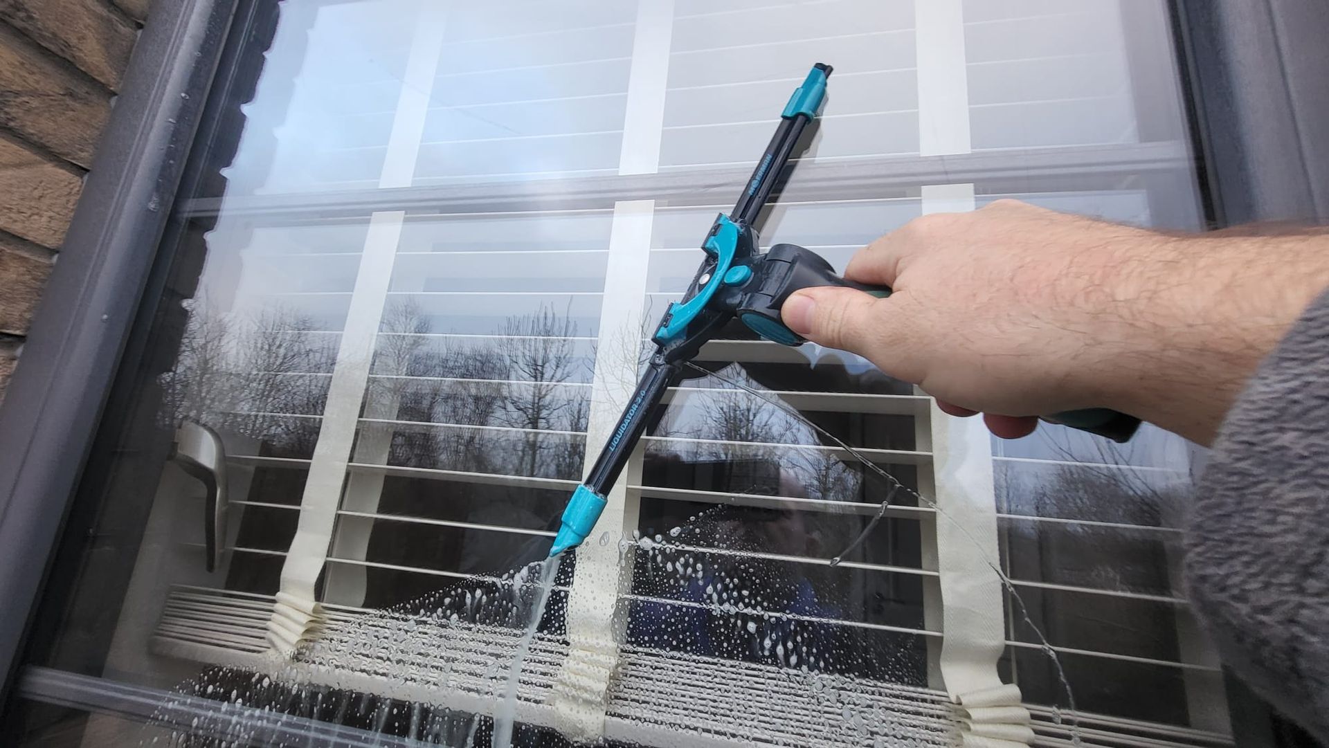 A person is cleaning a window with a spray bottle.
