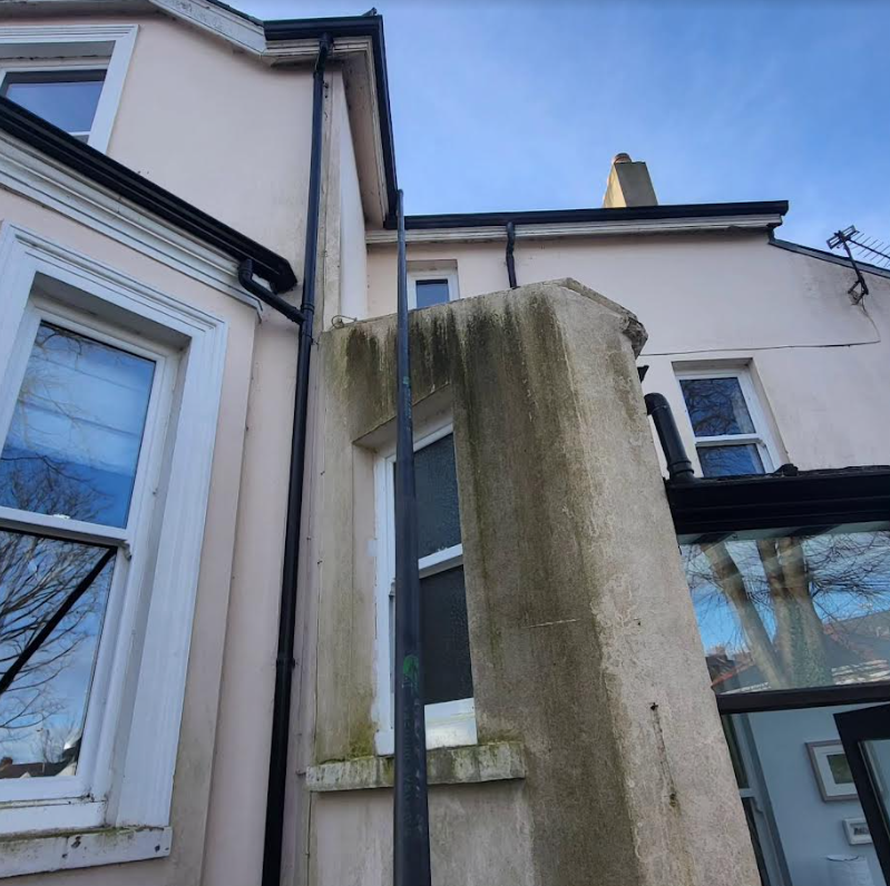 A house with a gutter on the side of it