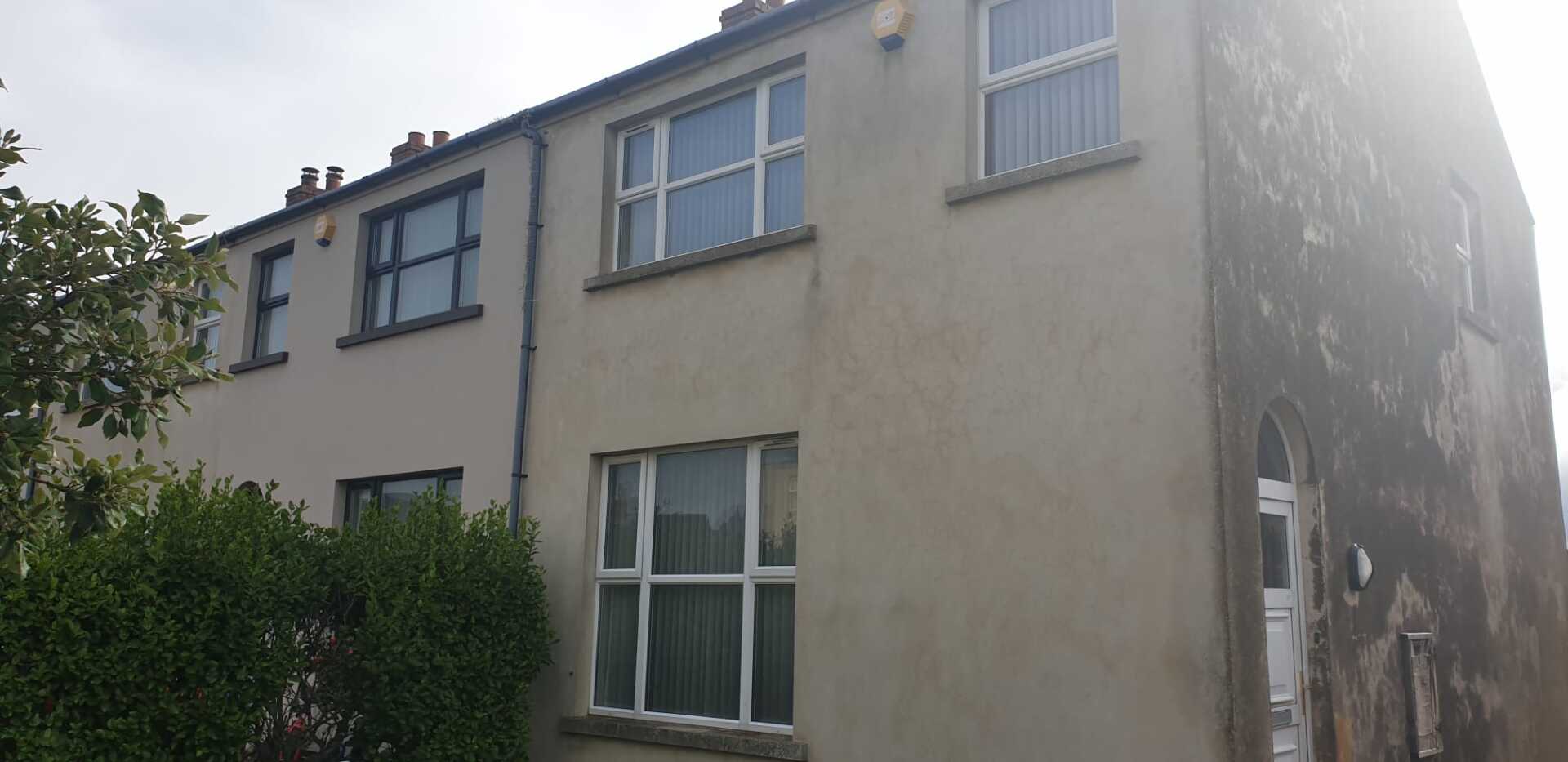 A large house with a lot of windows and trees in front of it.
