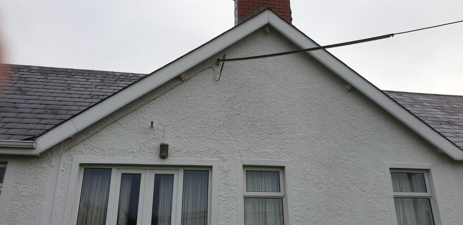 A white house with a chimney on top of it.