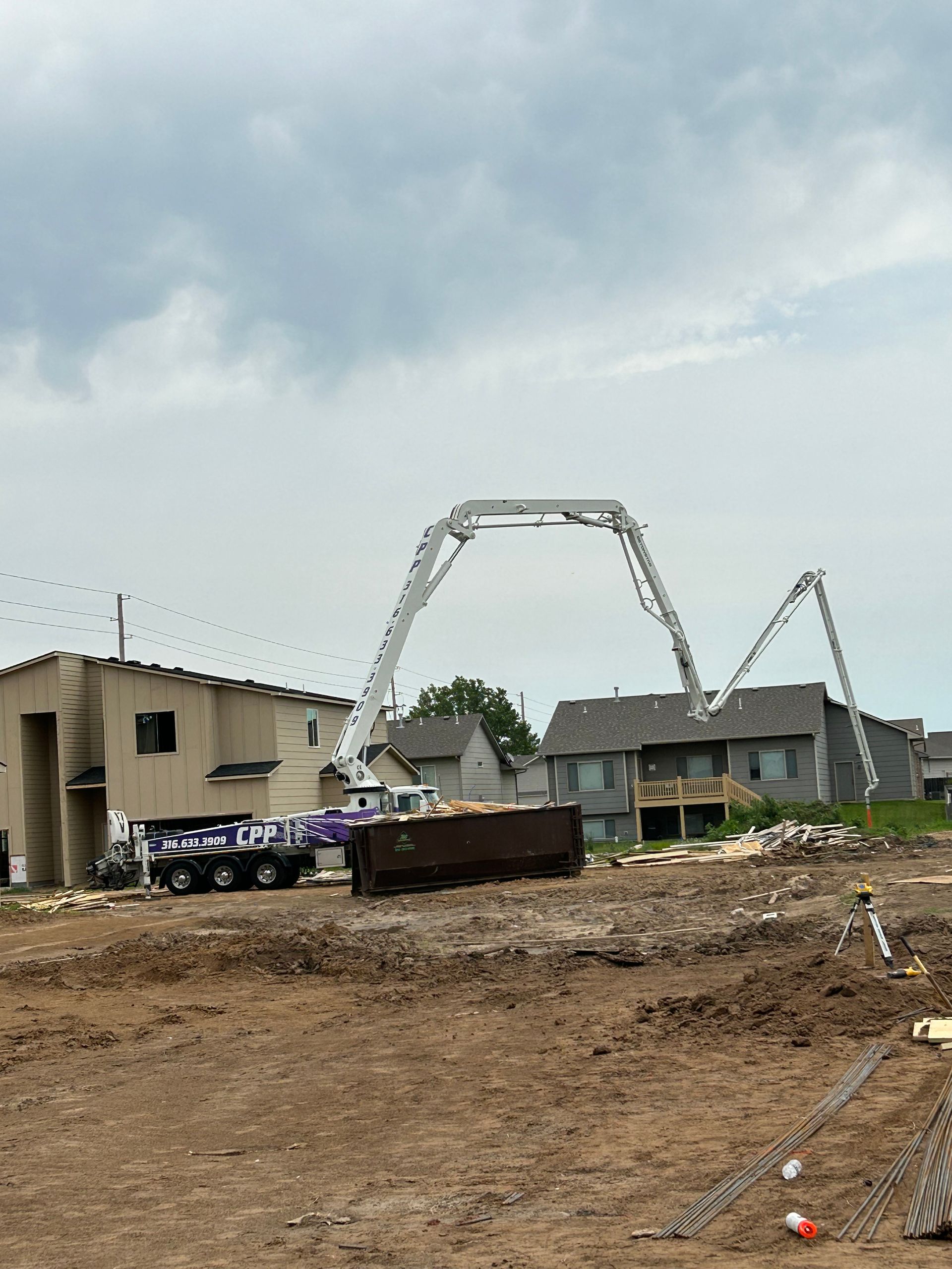 A concrete pump is being used to pour concrete on a construction site.
