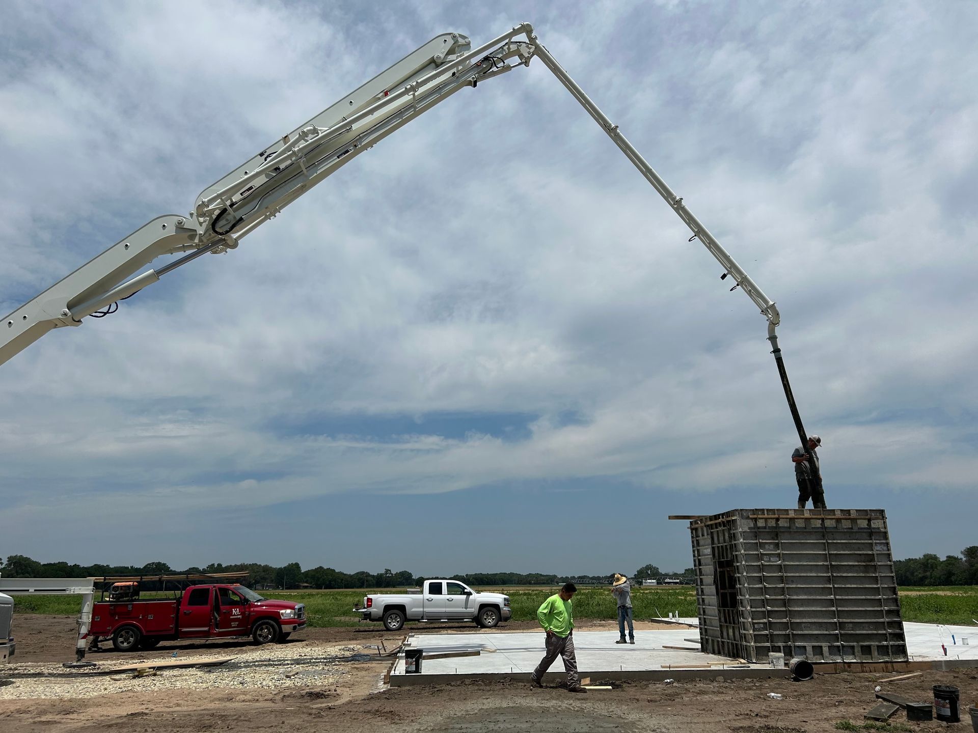 A concrete pump is being used to pour concrete into a building.
