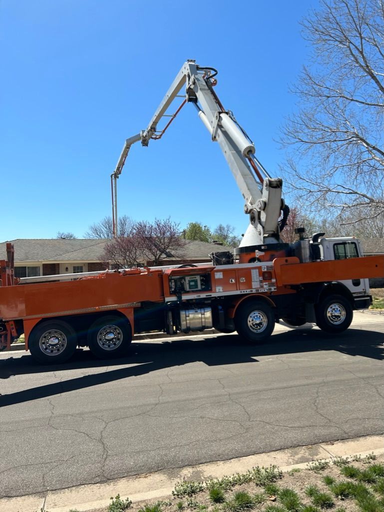 A concrete pump truck is parked on the side of the road.