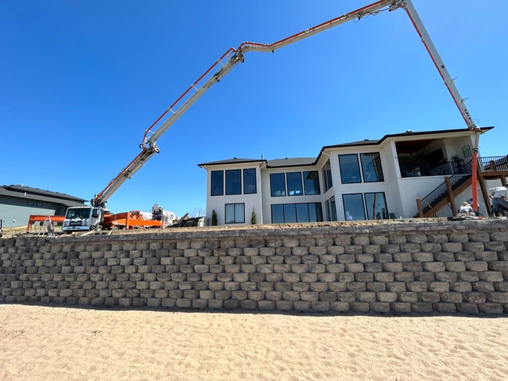 A large house is being built on the beach with a concrete pump.