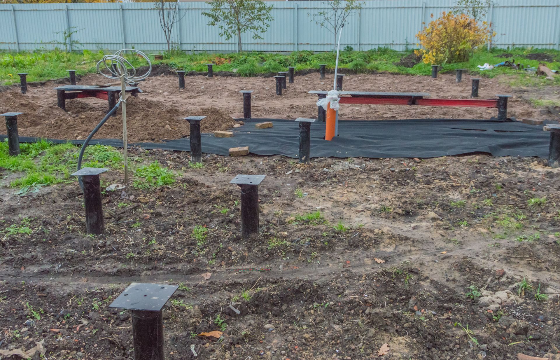 Construction site with metal posts and black tarp on the ground. Construction site with metal posts and black tarp on the ground.