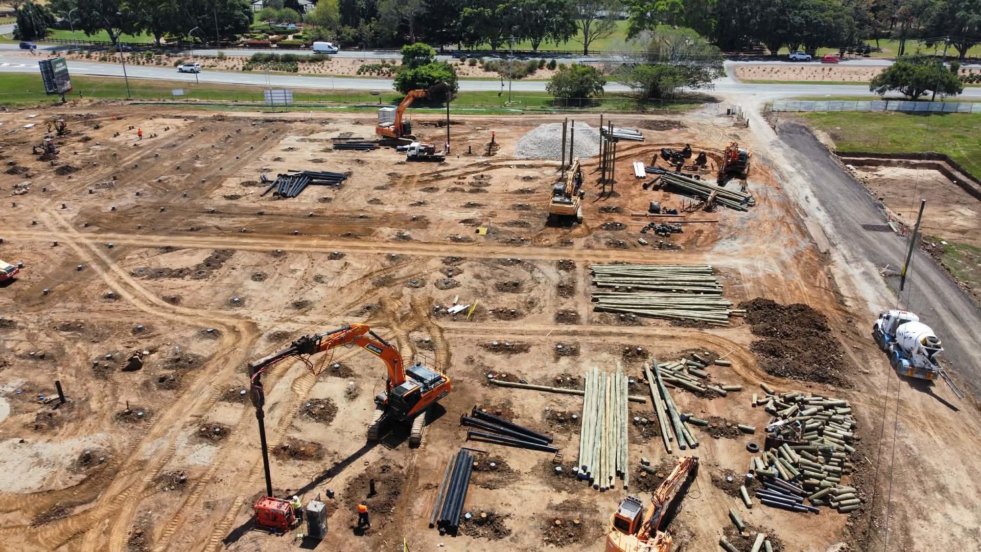 Aerial perspective of timber piling project, featuring excavators, piling rigs, and timber piles being installed by an experienced piling contractor.