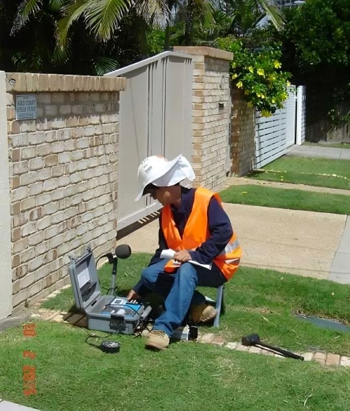 Engineer operating ground vibration monitoring instruments during soil testing.