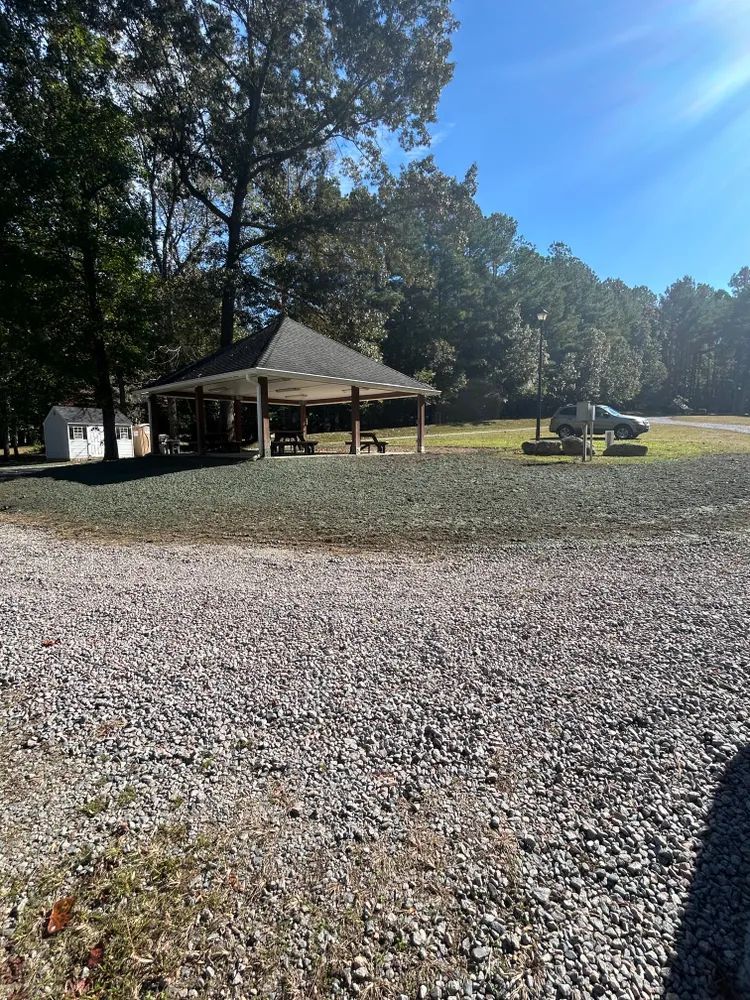 A gravel road leading to a pavilion in the woods