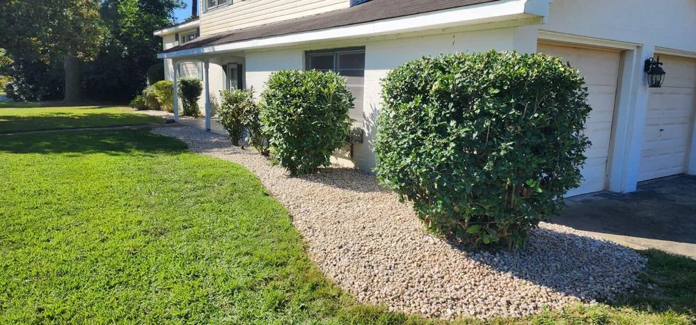 A house with a gravel walkway leading to it and a garage.