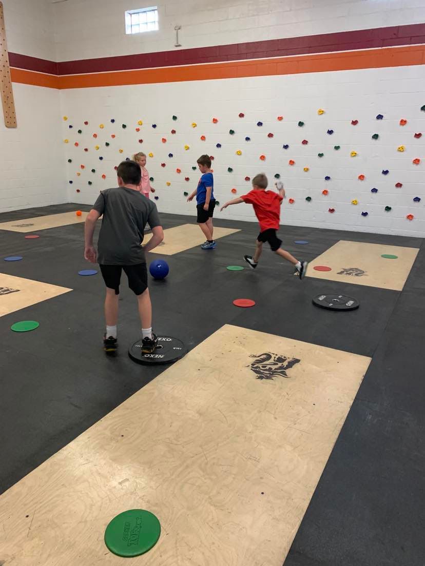 A group of young boys are playing a game in a gym.