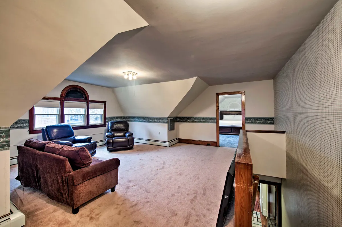 A living room with a couch and chairs in a house.