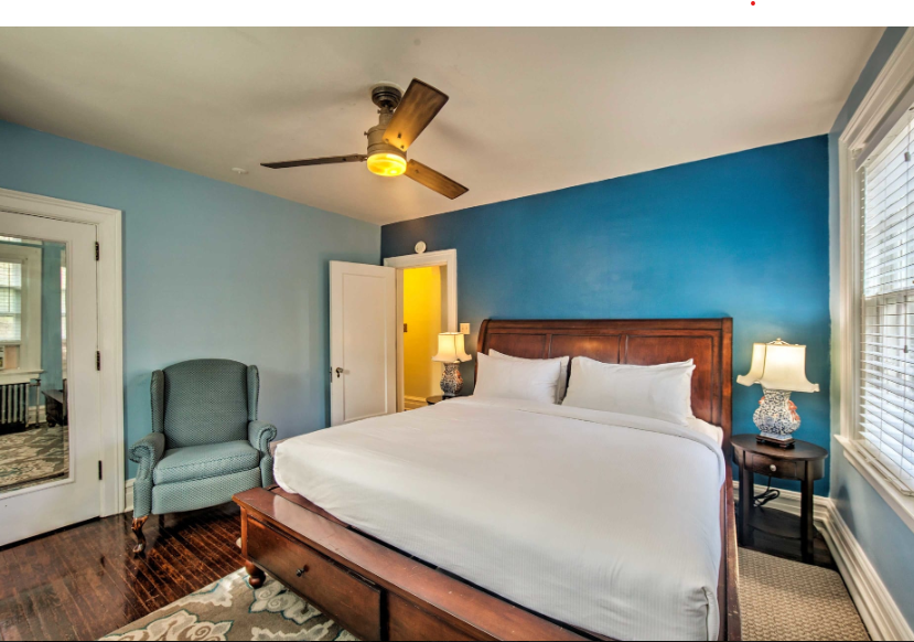 A bedroom with a king size bed and a ceiling fan